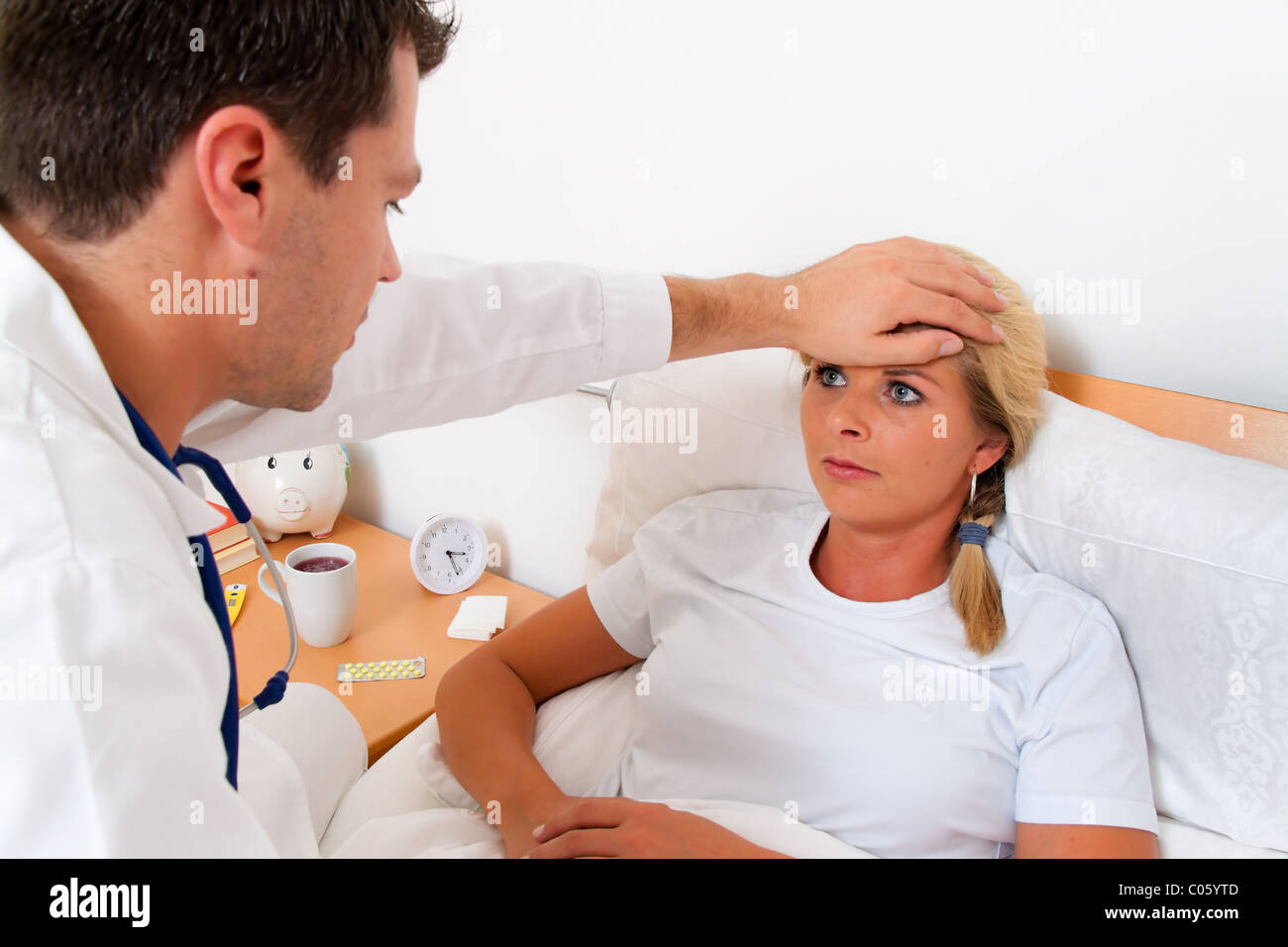 Doctor house call. Examined sick wife. Stock Photo