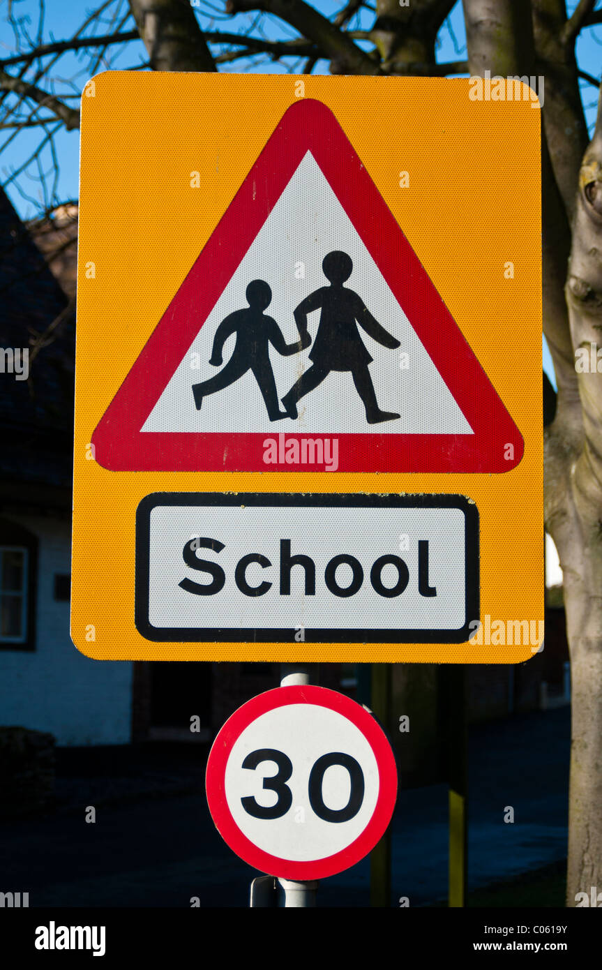 Road sign warning of children crossing near a school, and 30 speed limit in force. Stock Photo