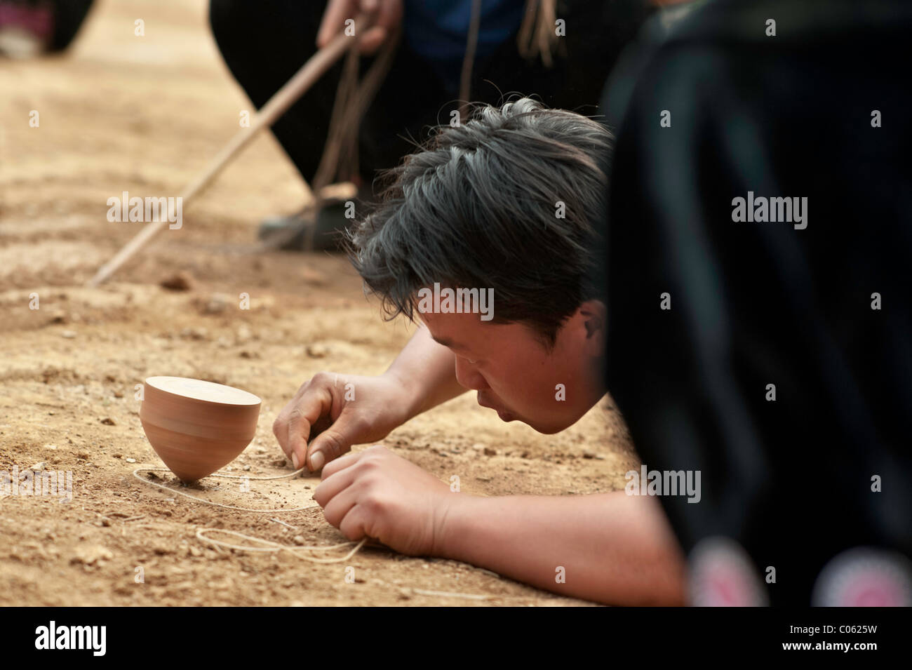 Traditional spinning top (Tujlub) competition action at a Hmong new