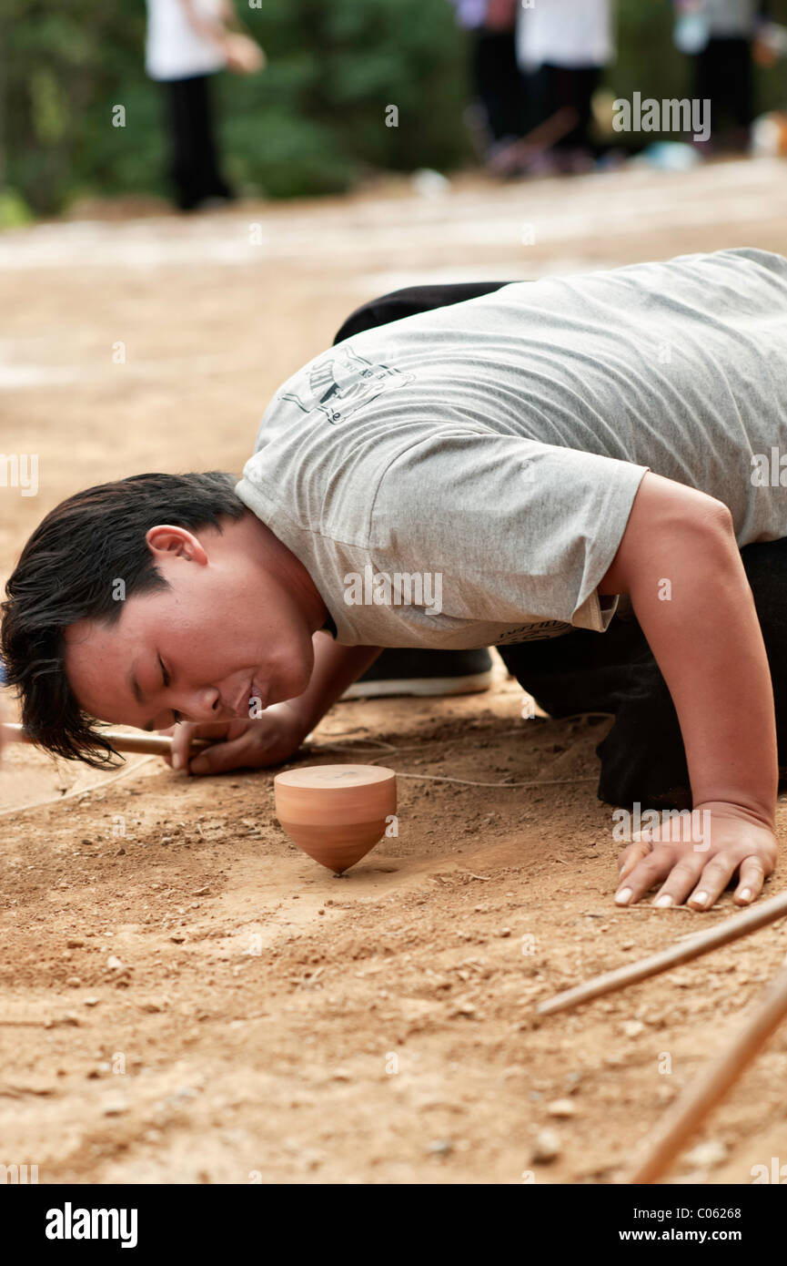 Traditional spinning top (Tujlub) competition action at a Hmong new