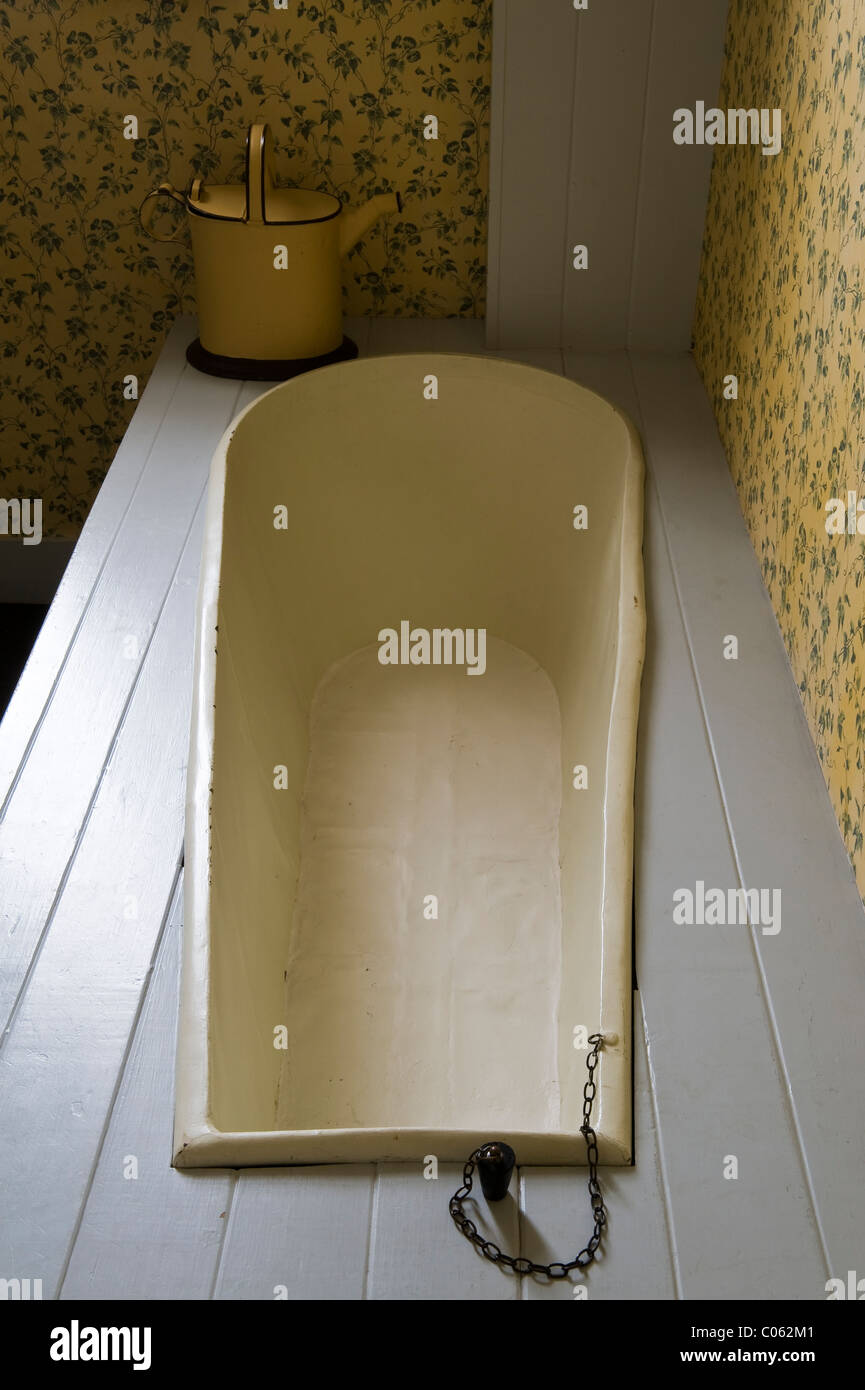 An original Victorian bath, with a water can for filling it before mains water arrived, at the Judge's Lodging museum, Presteigne, Powys, UK Stock Photo