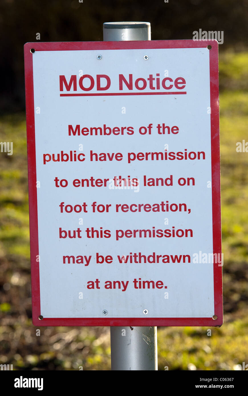 A UK MOD warning sign advising the public that they have access, but that access can be withdrawn at any time. In a UK village. Stock Photo