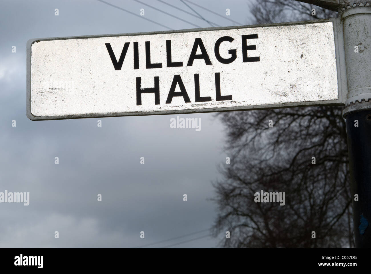 A sign pointing to a British village's Village Hall.  Village Halls are often the centre of the social life of a village. Stock Photo
