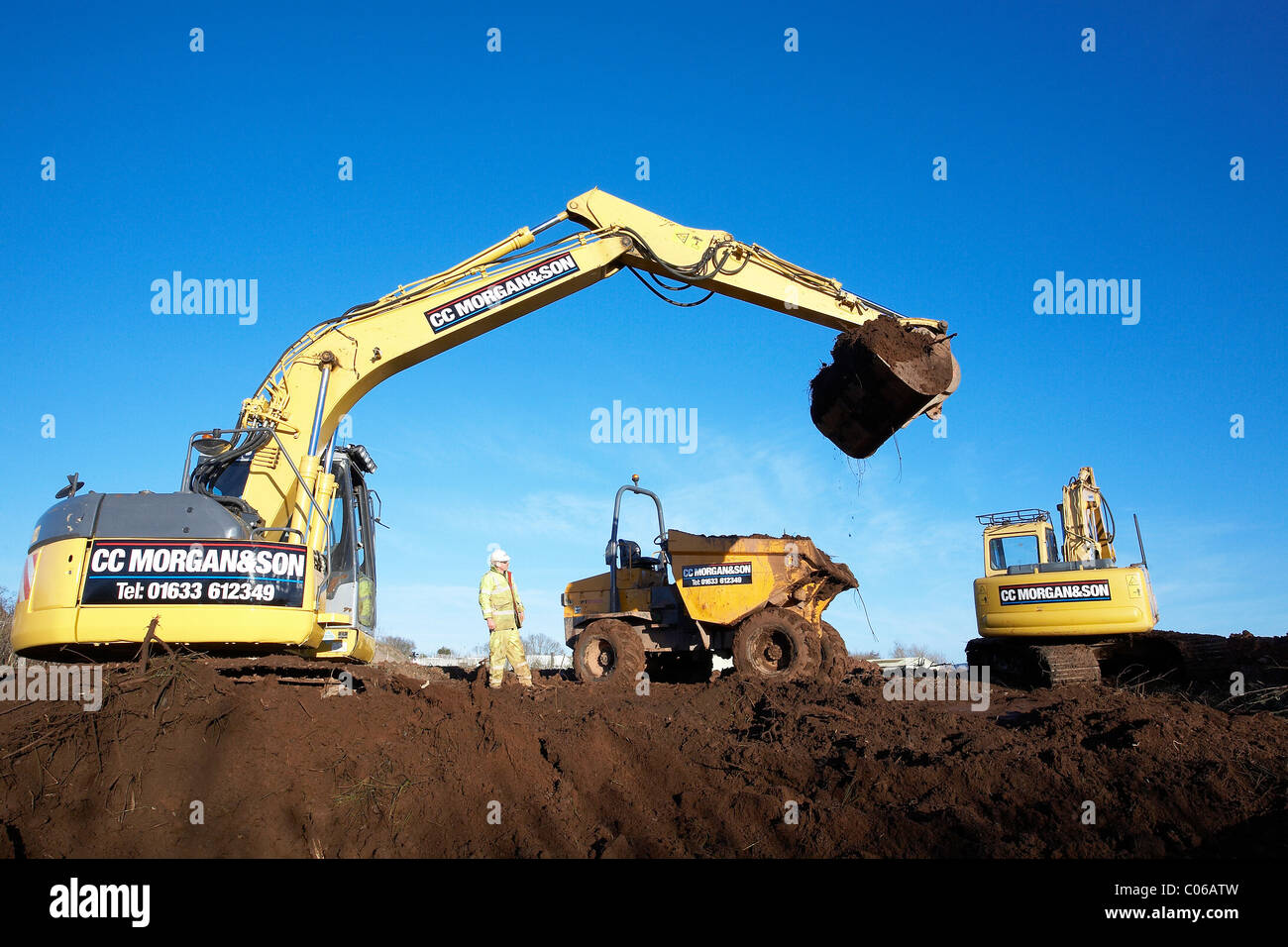 Mechanical diggers excavating earth on a building site. Stock Photo