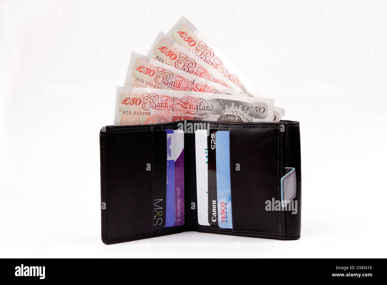 An opened mans wallet with displayed Bank and Store cards and UK fifty pound currency notes with a white background Stock Photo