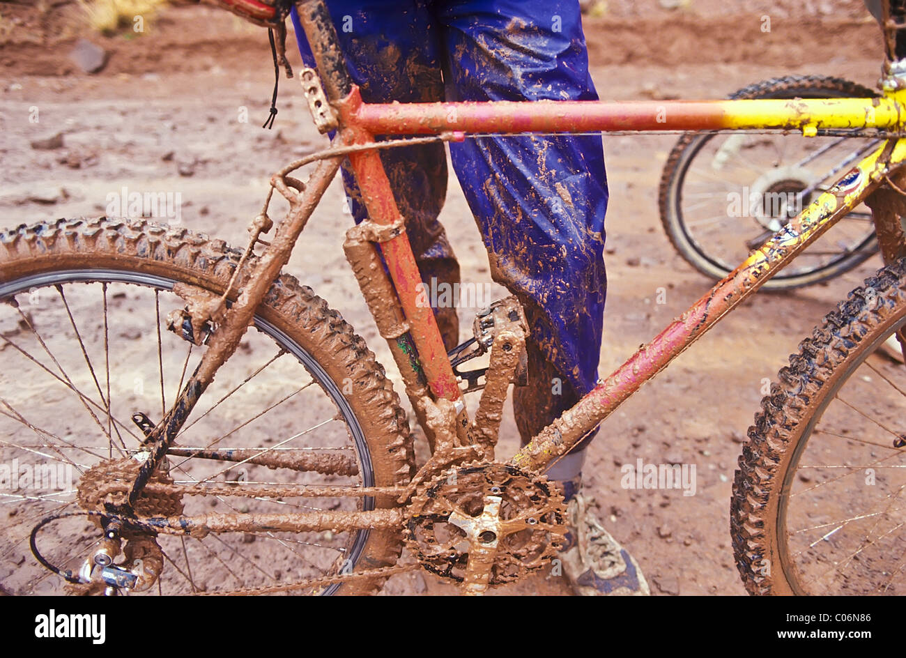 Muddy mountain bike and rider after a wet adventure in the rain. Stock Photo