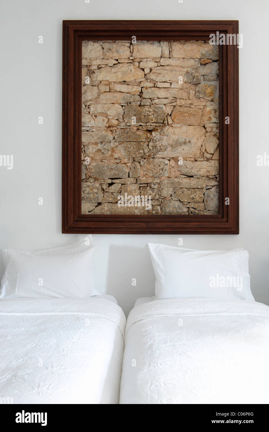 Stone wall framed over two beds Stock Photo