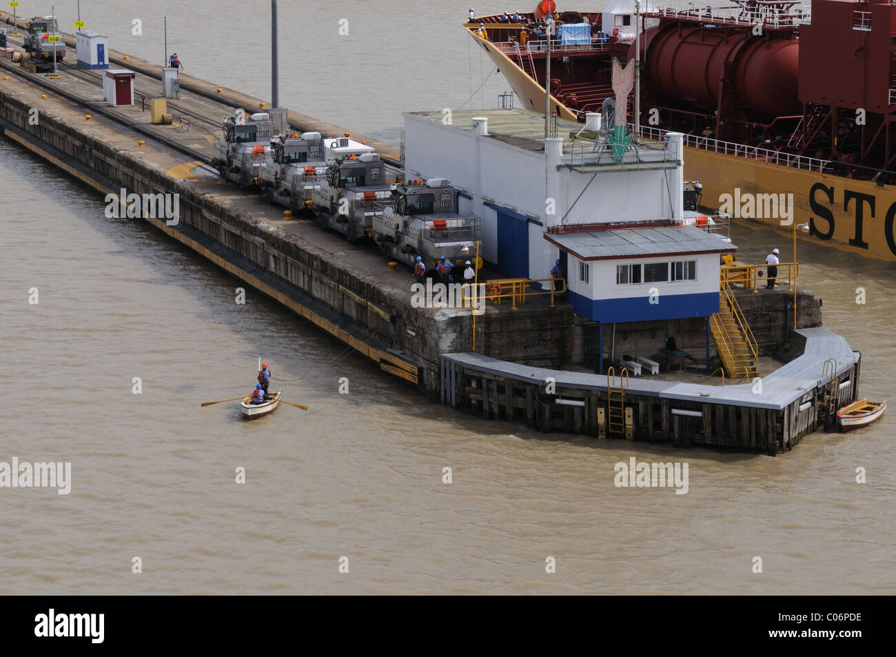 When ships go through Panama Canal locks, men in rowboats toss the