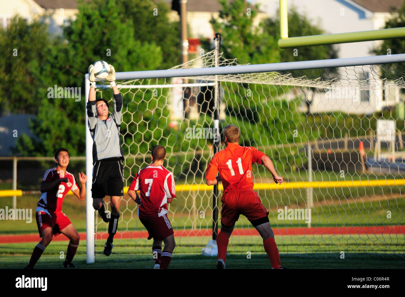 Goal keeper makes a save in a group of players high school soccer