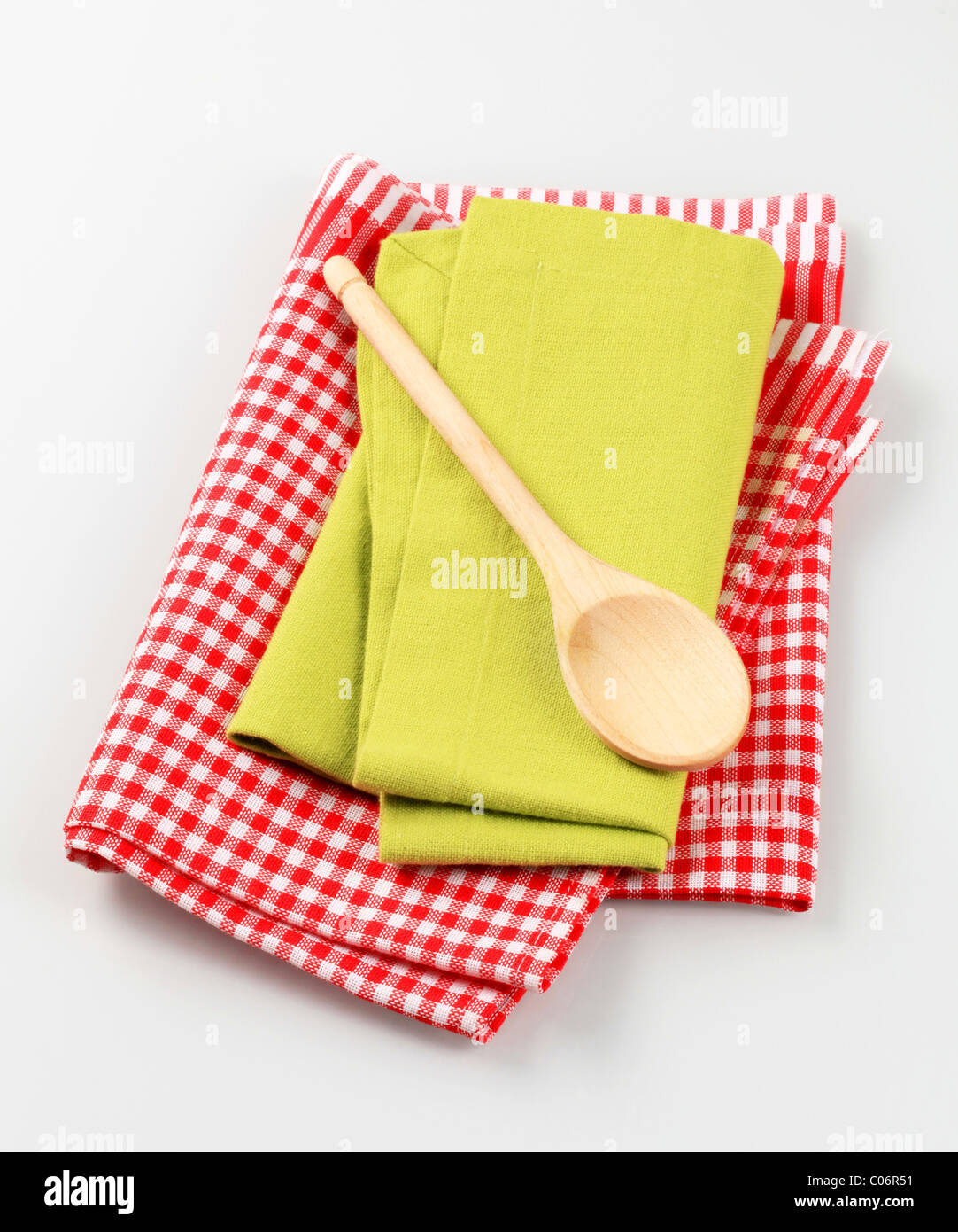 https://c8.alamy.com/comp/C06R51/wooden-spoon-and-tea-towels-C06R51.jpg