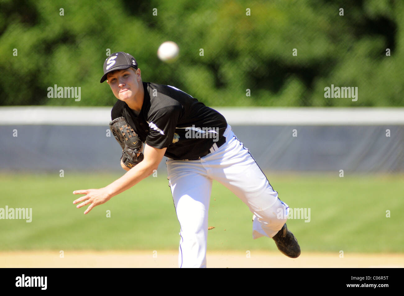 Pitcher follows through on a pitch during a high school baseball game