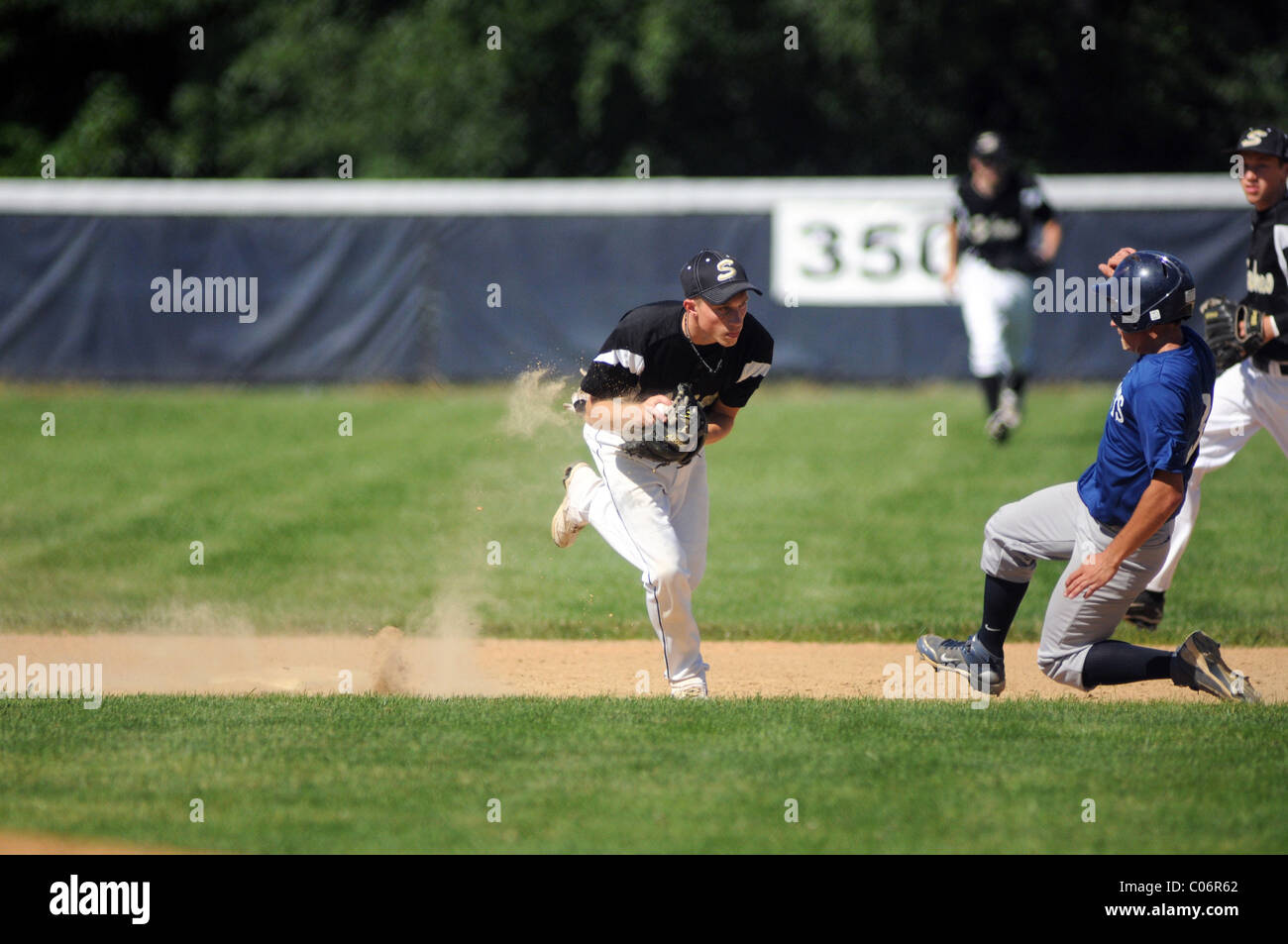 Shortstop fields a ground ball to his left and avoids a sliding runner