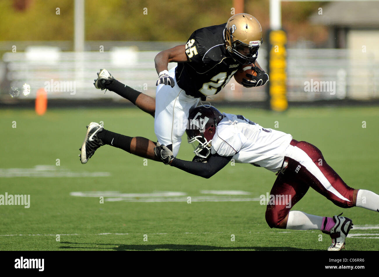 Running back taking the high road as he is upended by a tackle. USA. Stock Photo
