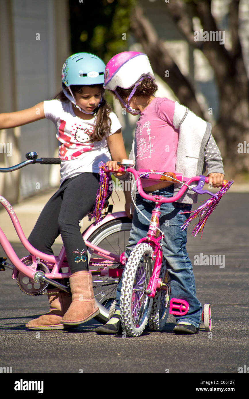 A five year old girl learns to ride her new bicycle in a safe parking