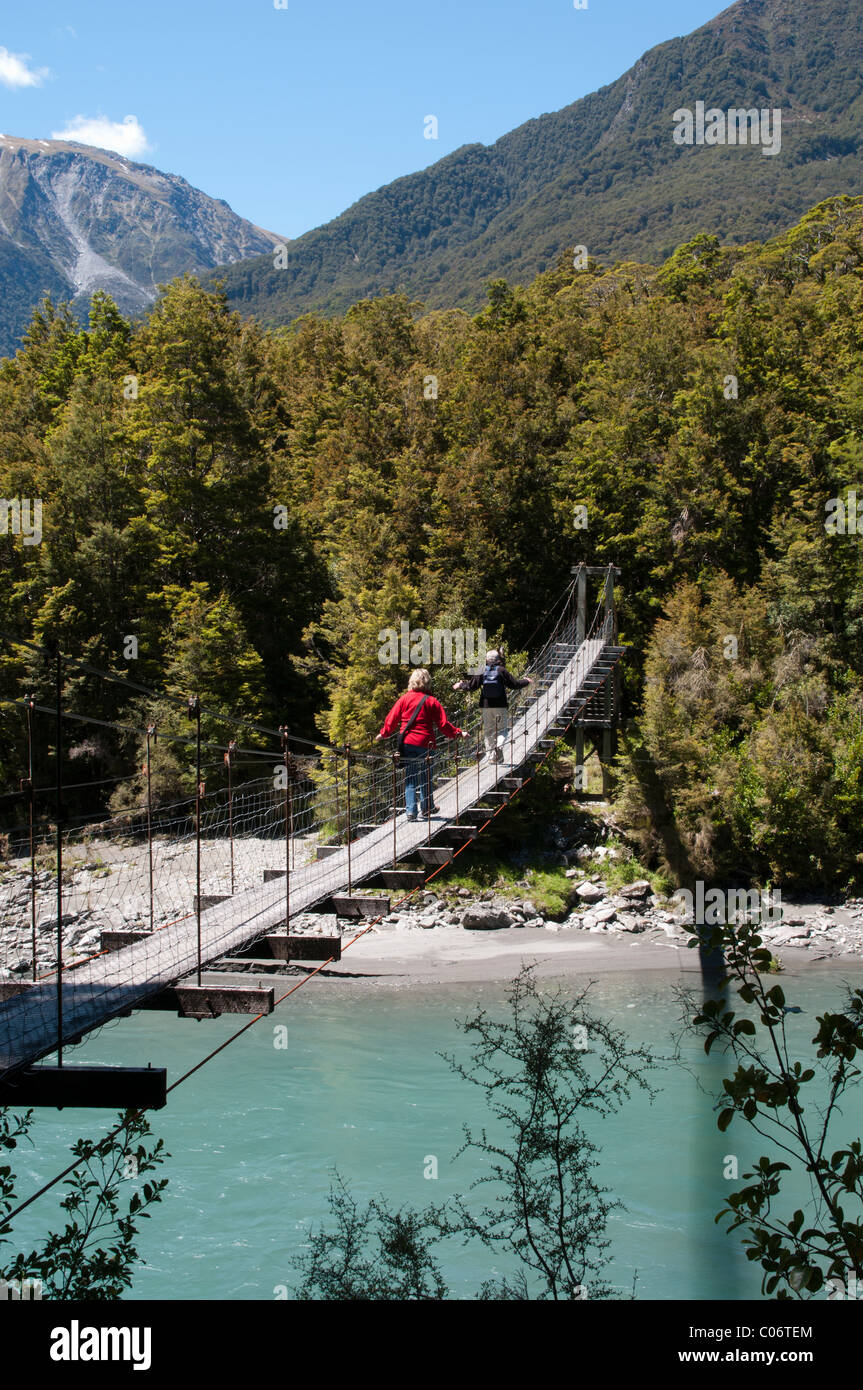 A swingbridge crosses the Makarora River near the Haast Pass   Eine Hängebrücke quert den Makarora-Fluß in Neuseeland Stock Photo