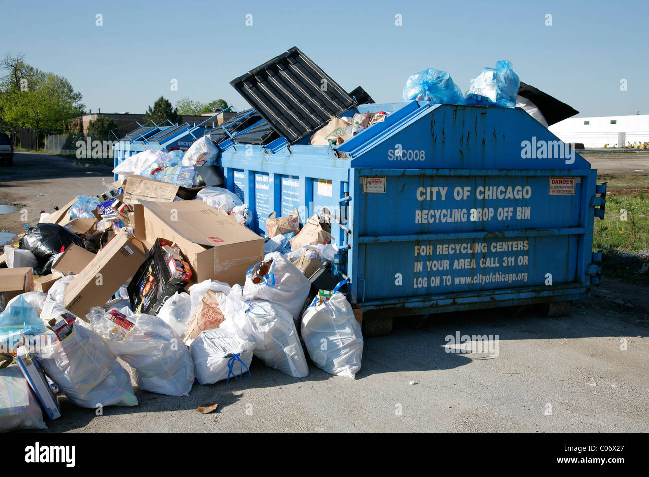 Recycle center drop off container overflows with bags and boxes of
