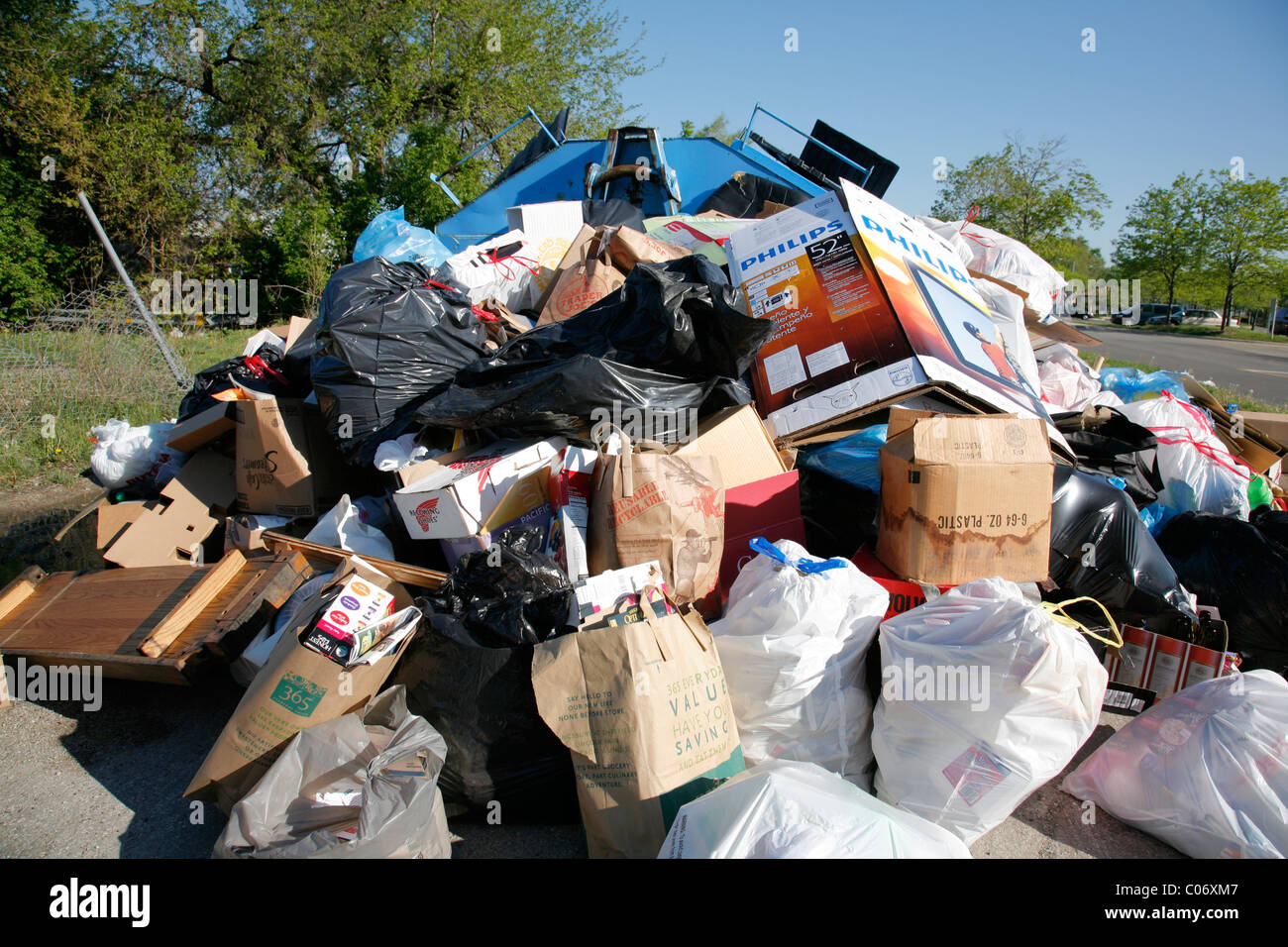 Recycle center drop off container overflows with bags and boxes of
