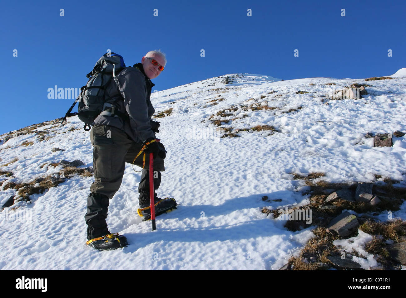 Hiker ascending Stob Coire Easian. Stock Photo