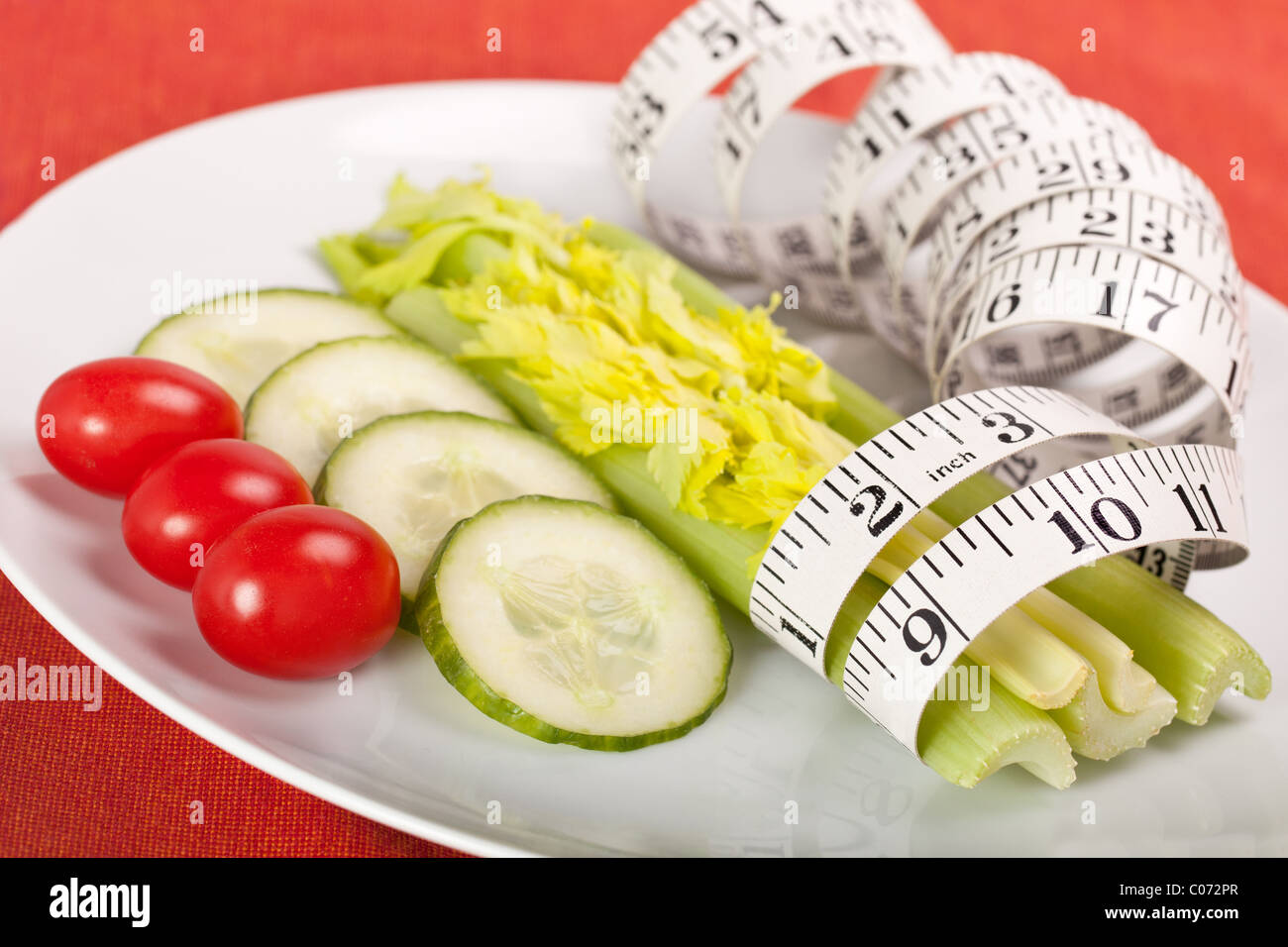Strict Salad Diet on White Plate with Tape Measure Stock Photo