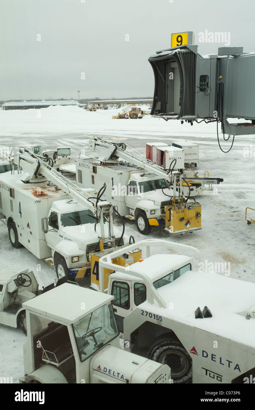 At Bradley International Airport, de-icing and snow removal equipment at an airline gate waits for a major storm to abate. Stock Photo