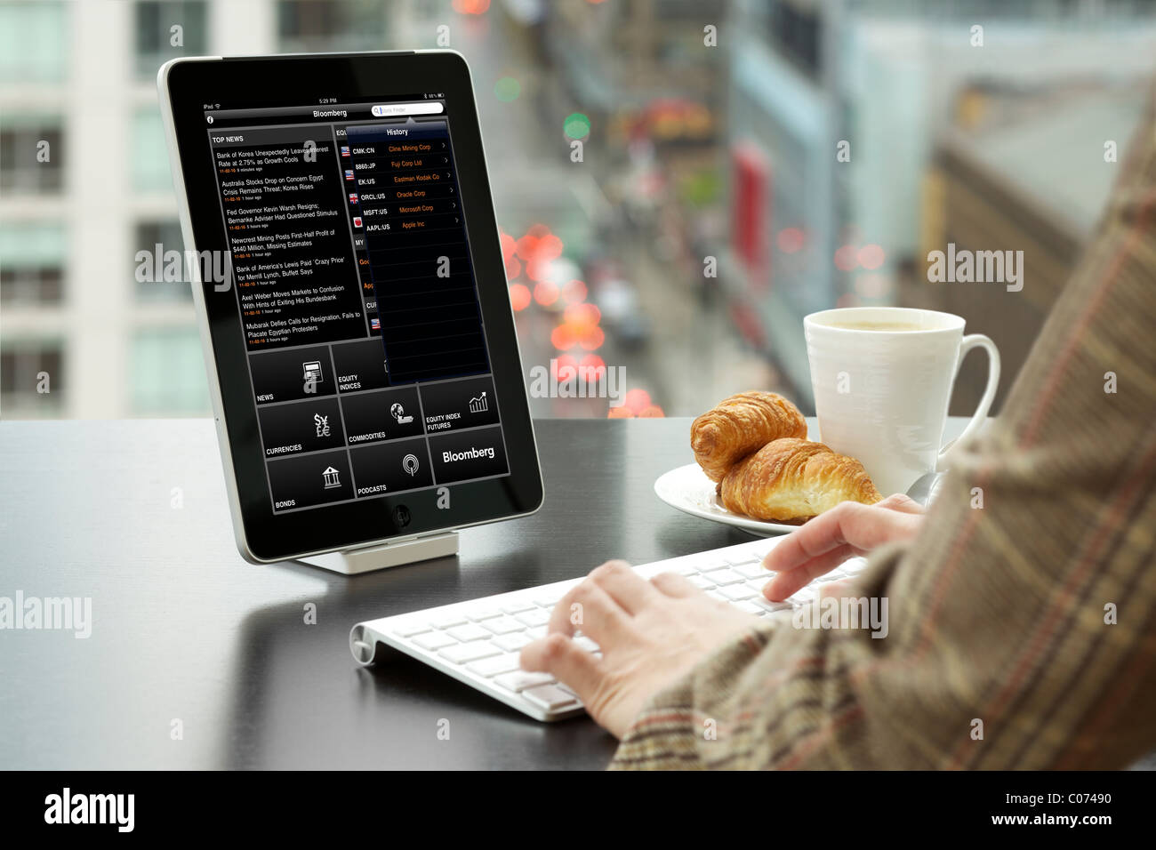 Business woman analyzing FTSE 100 Index financial information with Bloomberg iPad app at an office Stock Photo