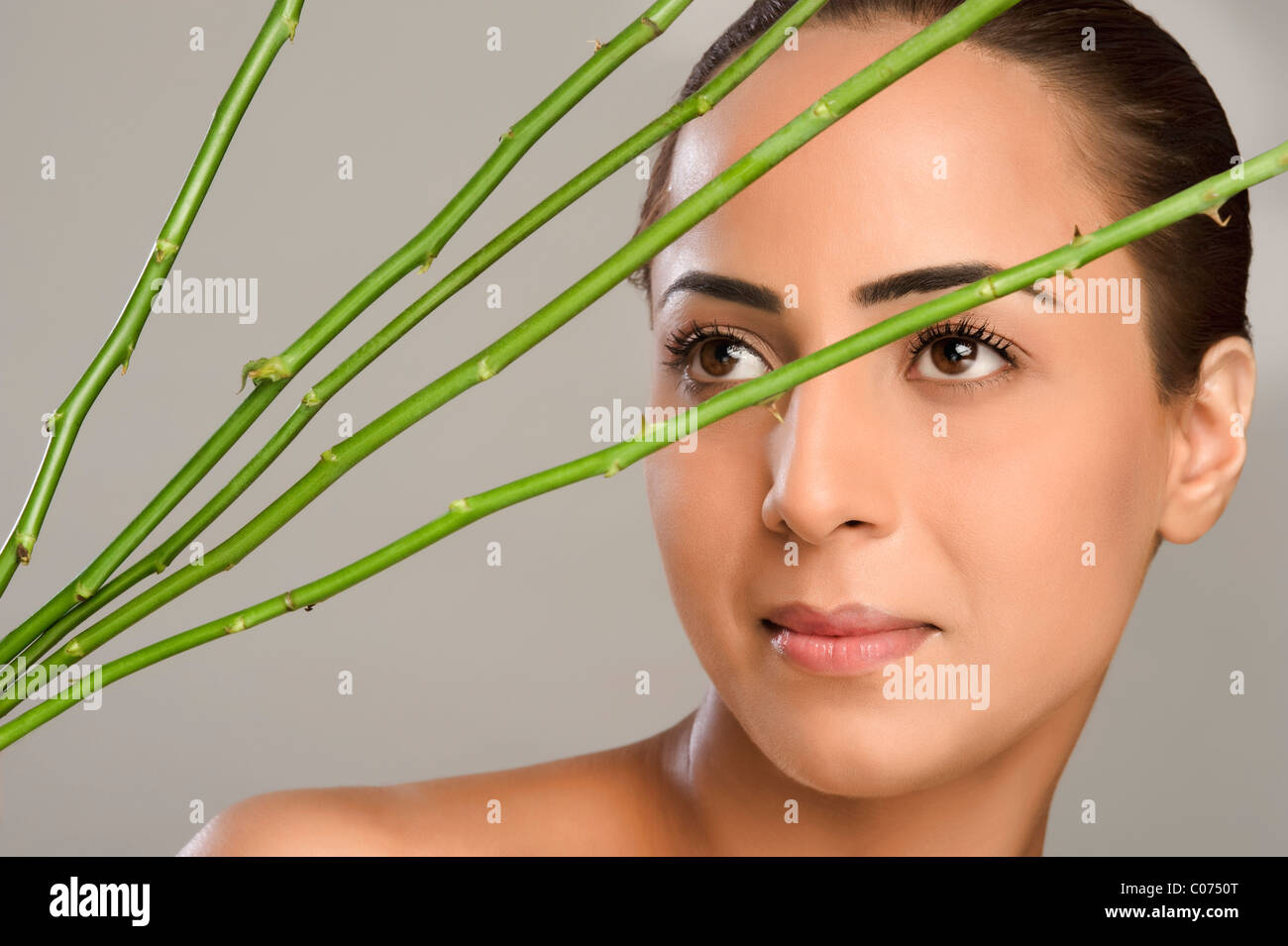 Close-up of a woman with rose stems in front of her face Stock Photo ...