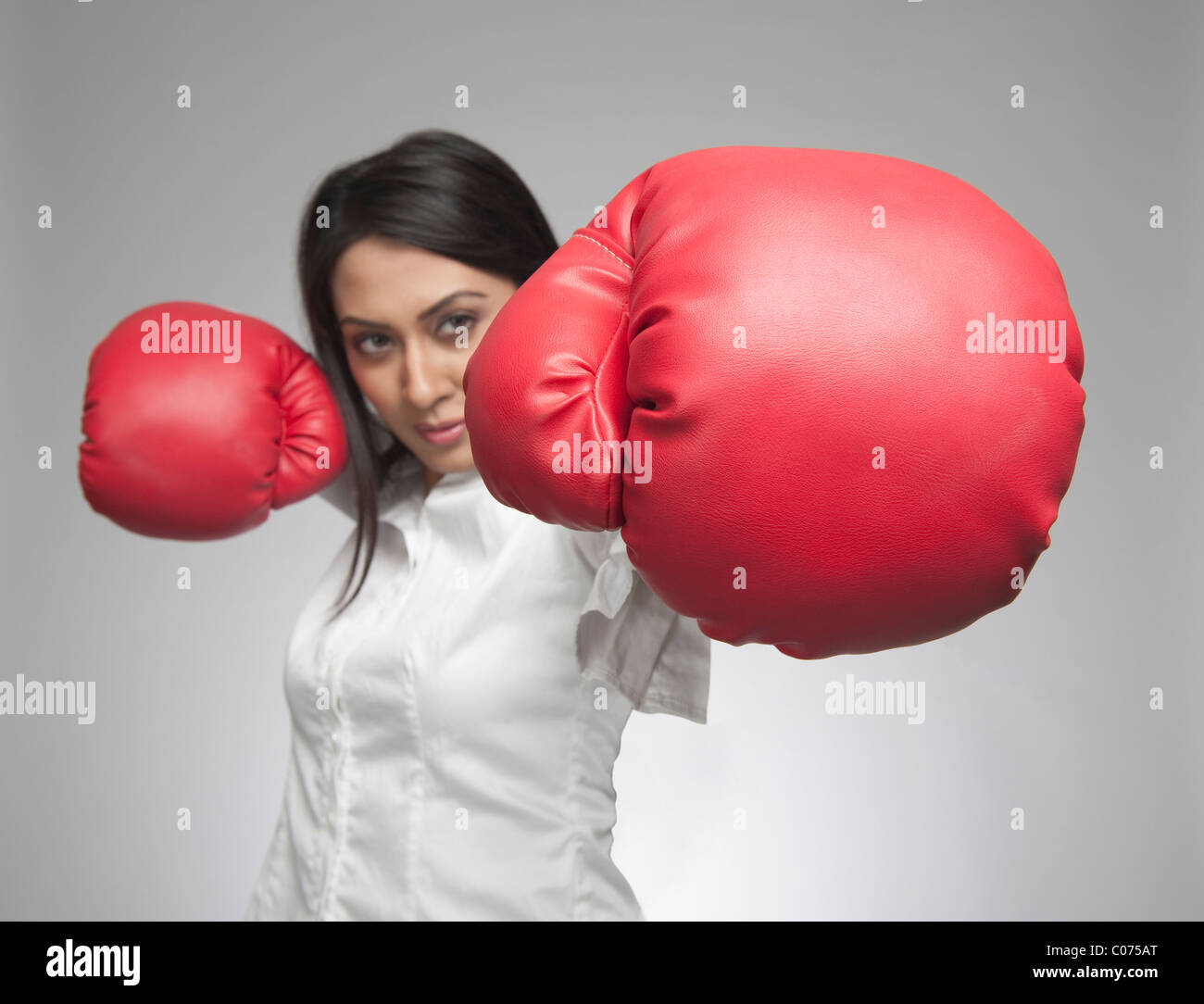 Businesswoman punching with boxing gloves Stock Photo Alamy