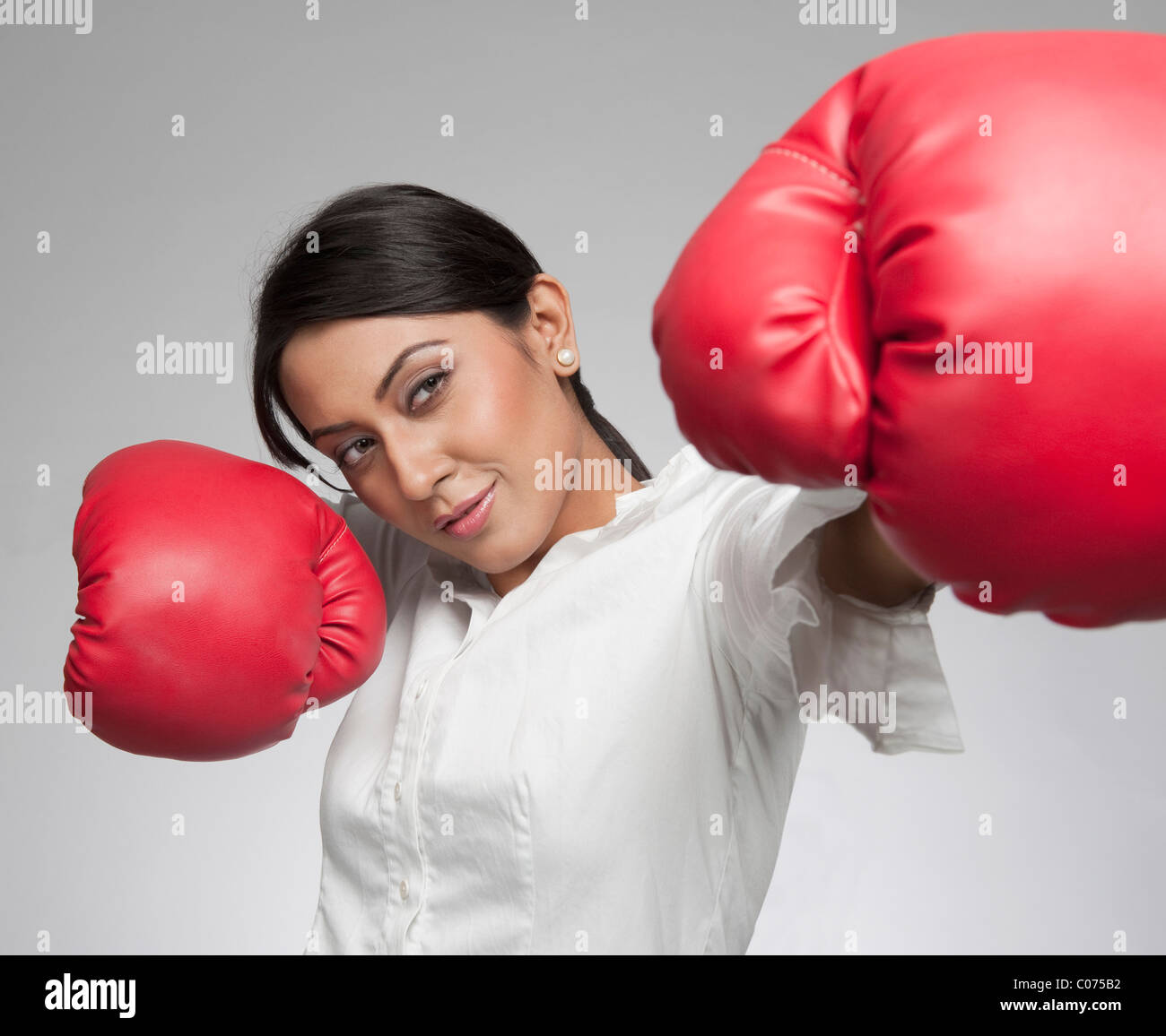 Businesswoman punching with boxing gloves Stock Photo Alamy