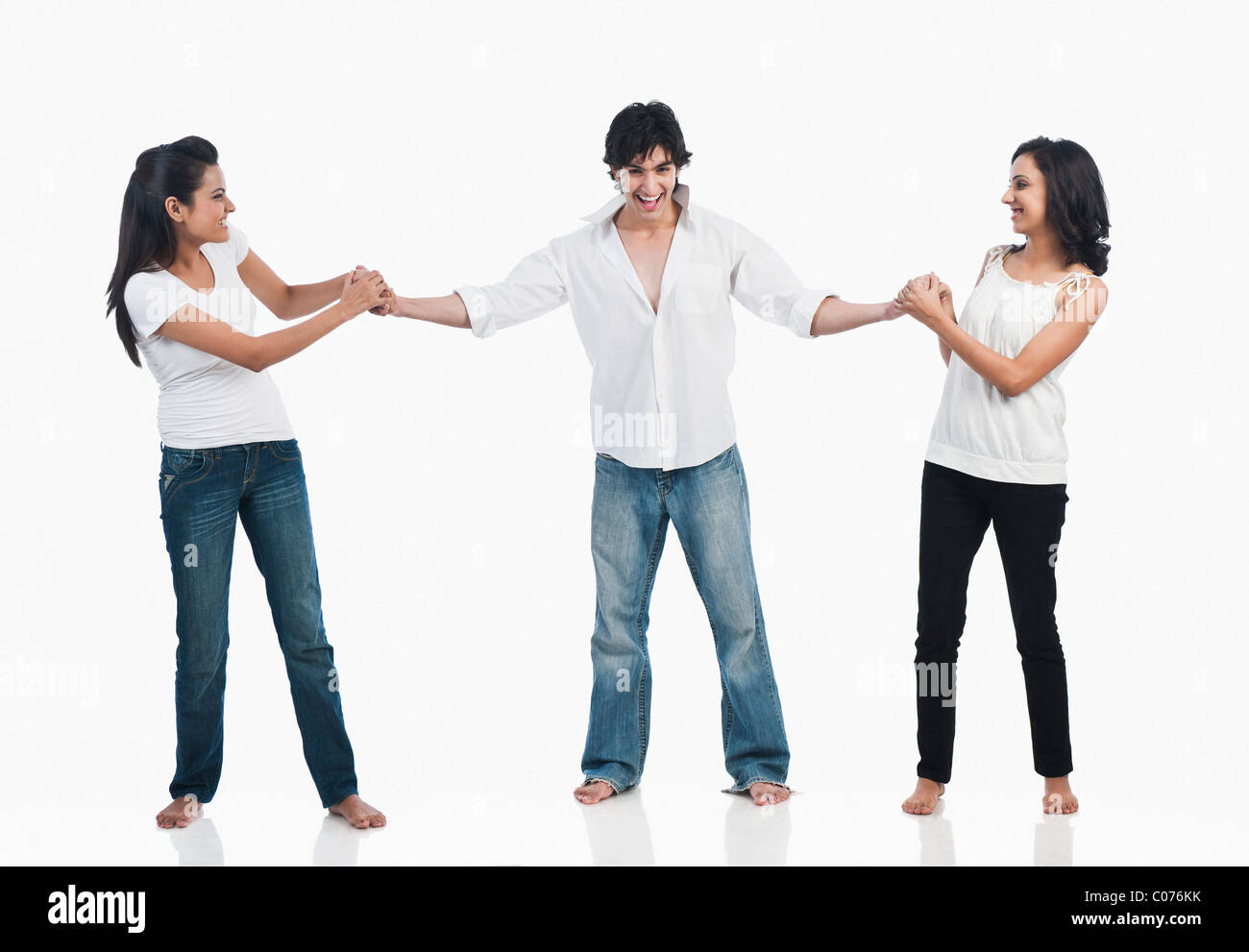 Two women pulling a men Stock Photo Alamy