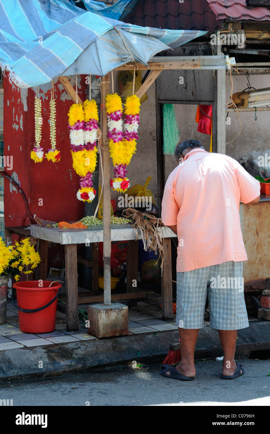 man making fresh flower garlands outside Sri Mahamariamman Hindu Temple jalan bandar near petaling street kuala lumpur Stock Photo
