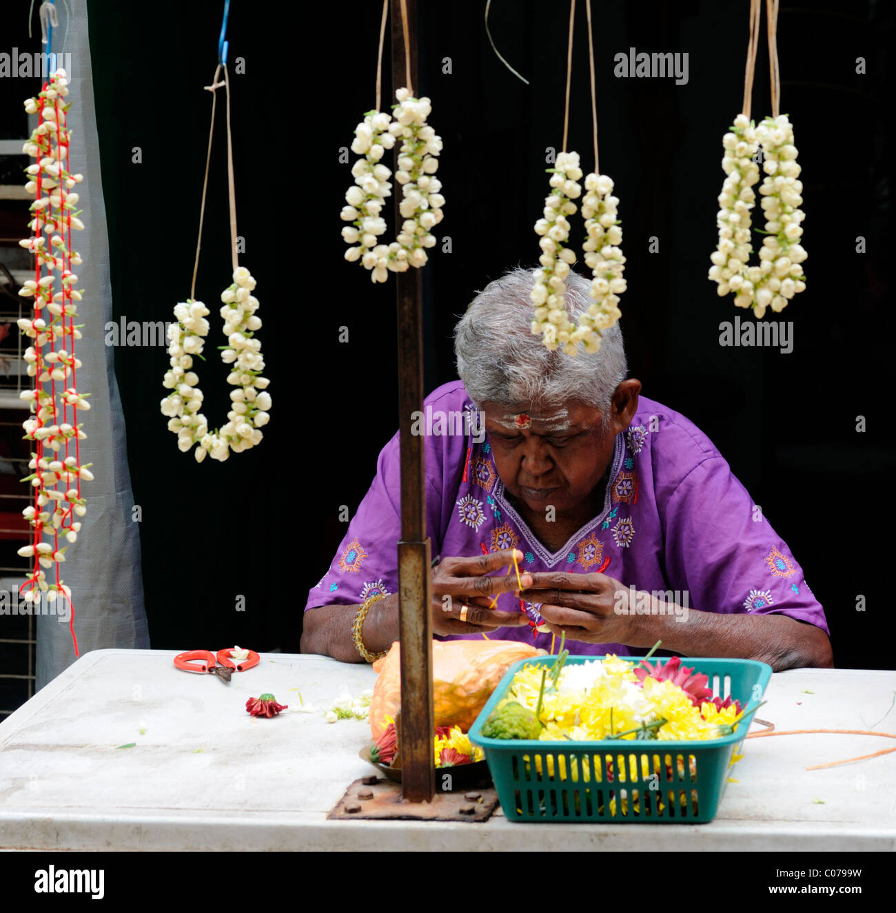 woman making fresh flower garlands outside Sri Mahamariamman Hindu Temple jalan bandar near petaling street kuala lumpur Stock Photo