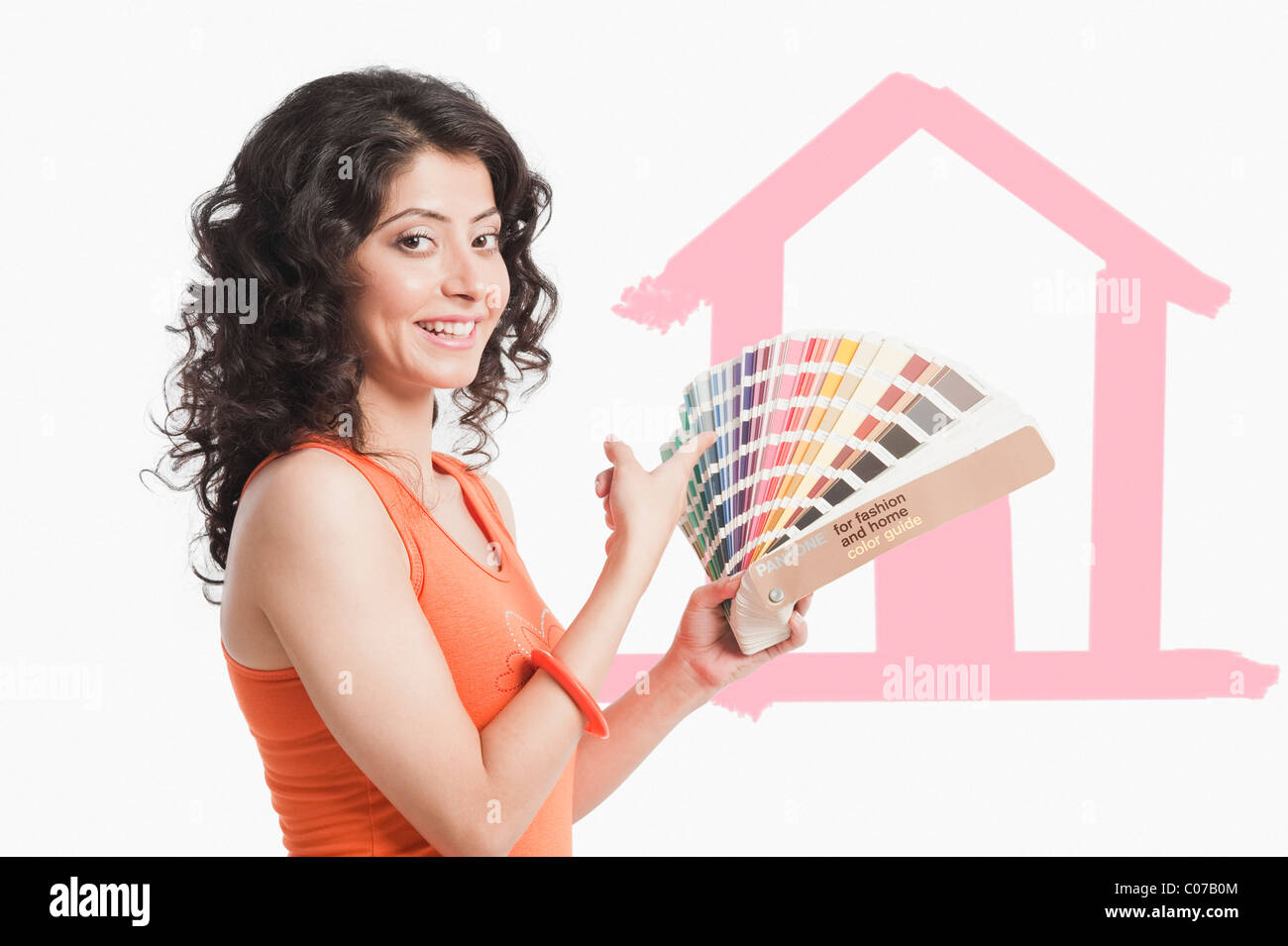 Woman choosing paint from color swatches for home Stock Photo