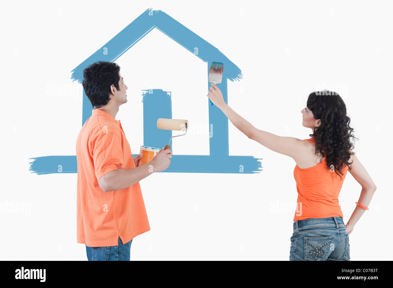 Couple painting a model home on the wall Stock Photo