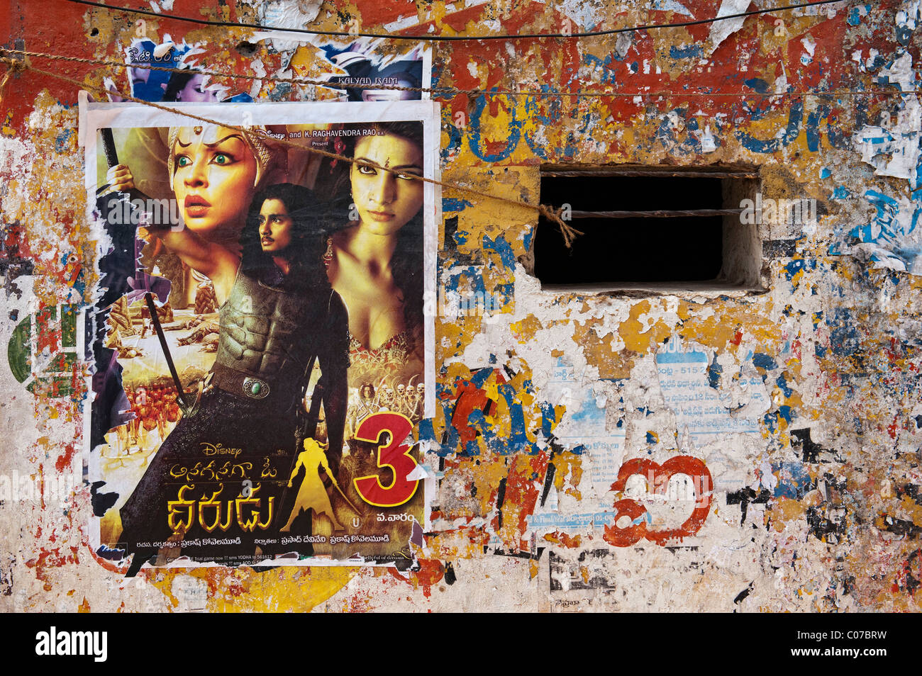 Indian movie posters on a tattered wall of an old rural indian house. Andhra Pradesh, India Stock Photo