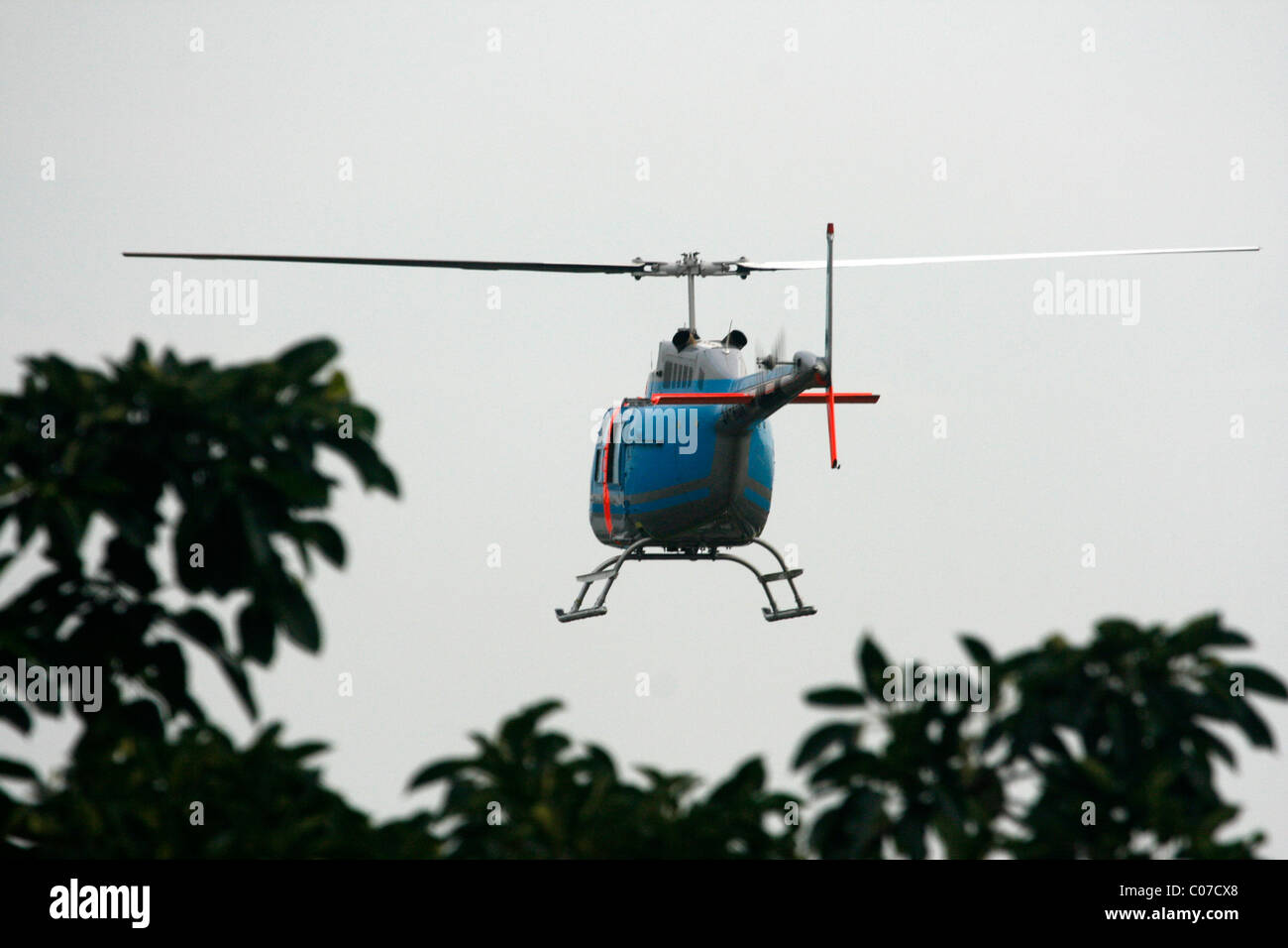 A Bell 206 JetRanger flying low to land, Uganda Stock Photo