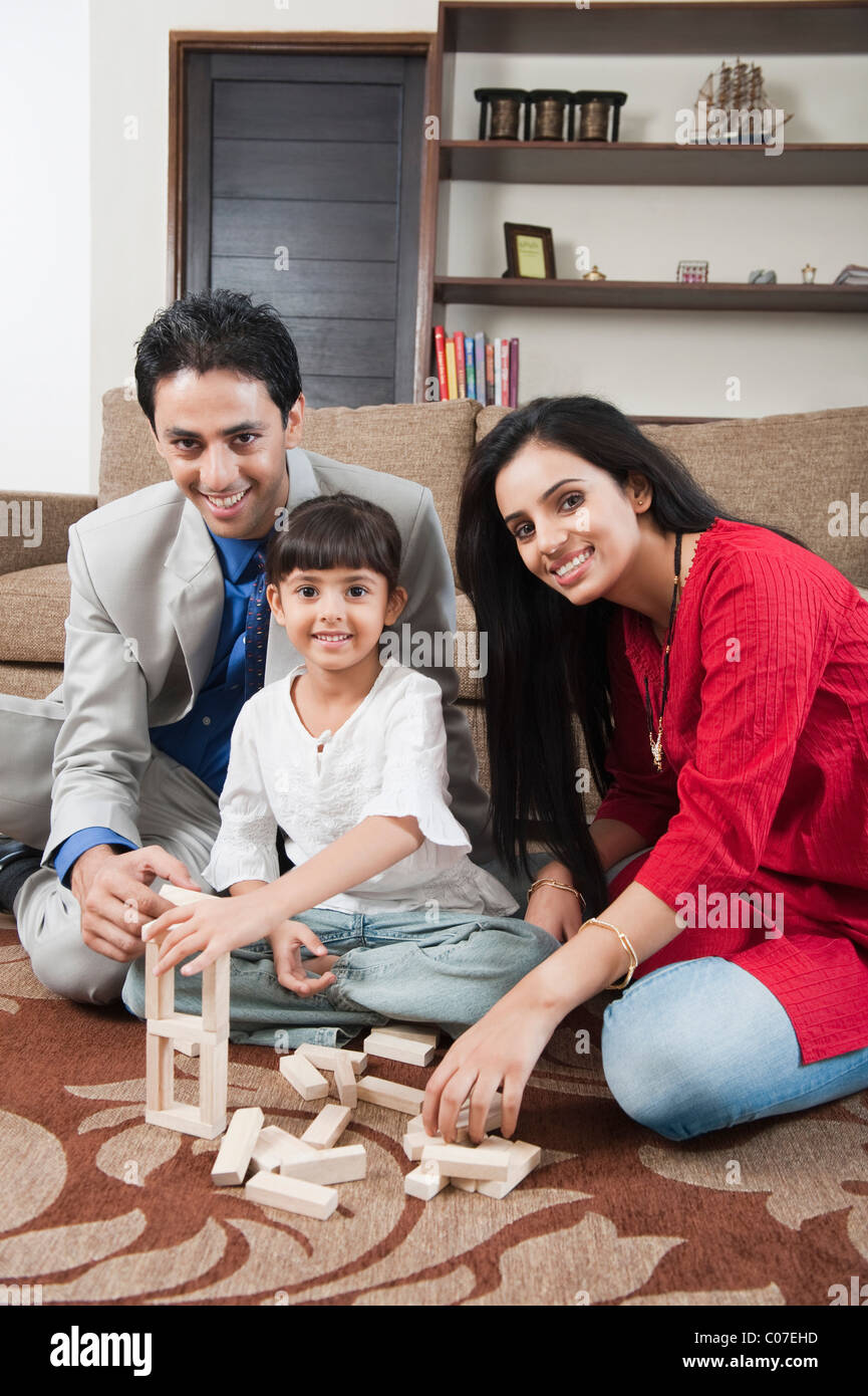 Girl playing Jenga with her parents Stock Photo - Alamy