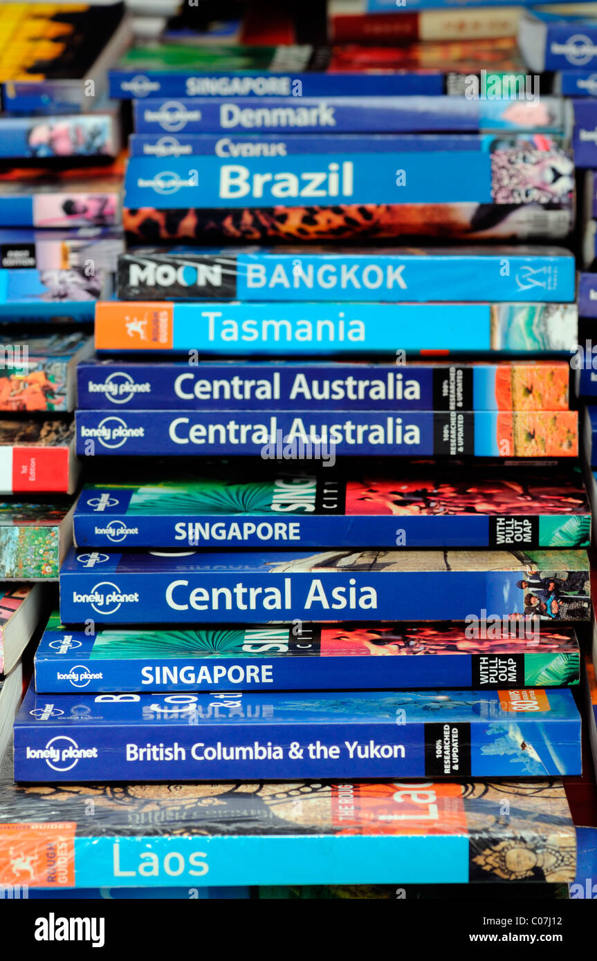 A pile stack bunch of lonely planet travel tour guide guides book books publications tourism help tourist handbook manual Stock Photo