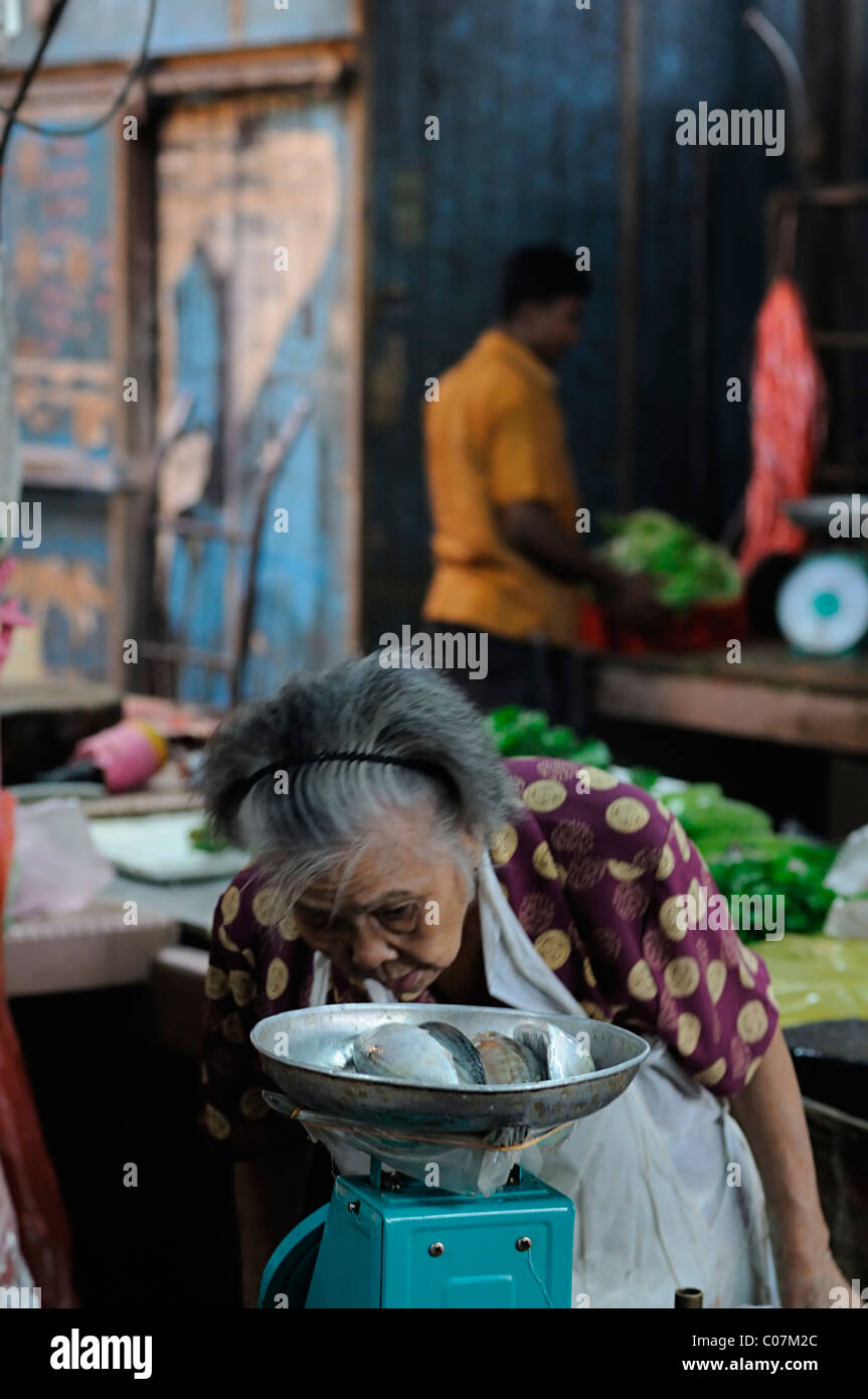 old woman weigh weighing out fish food wet market jalan petaling street kuala lumpur chinatown malaysia malaysian chinese food Stock Photo