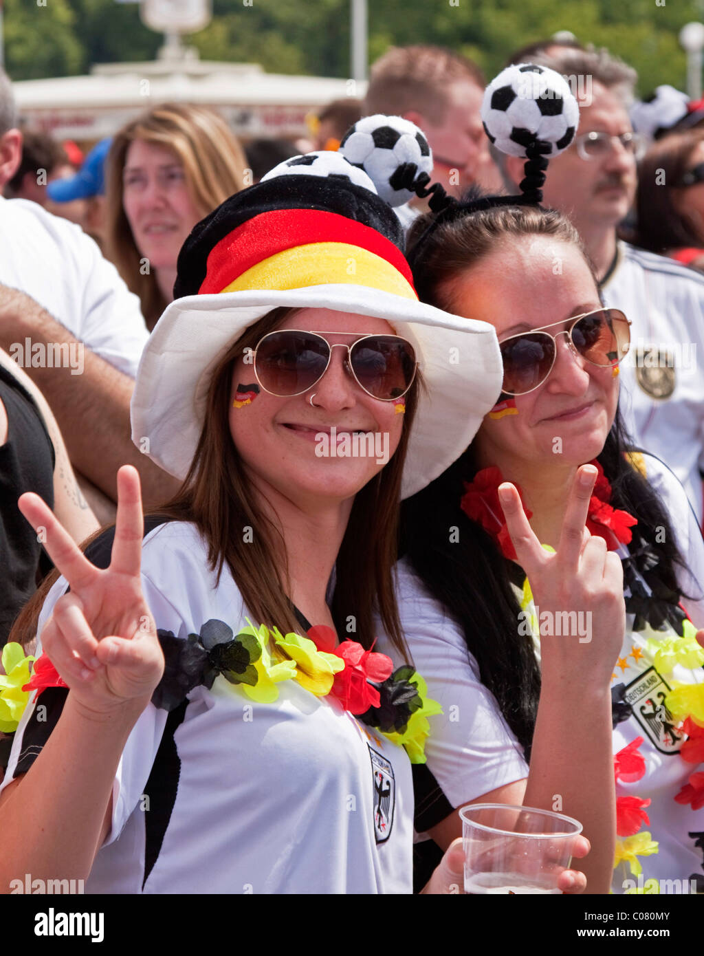 Two female soccer fans attending the public screening in front of the Olympic Stadium during the FIFA World Cup 2010, watching Stock Photo