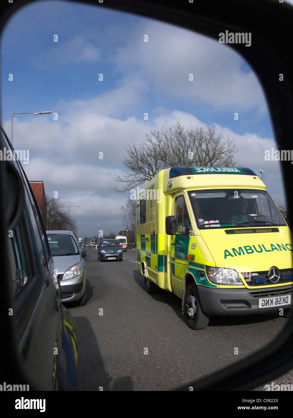 Speeding Ambulance as seen in car wing mirror. England UK Stock Photo
