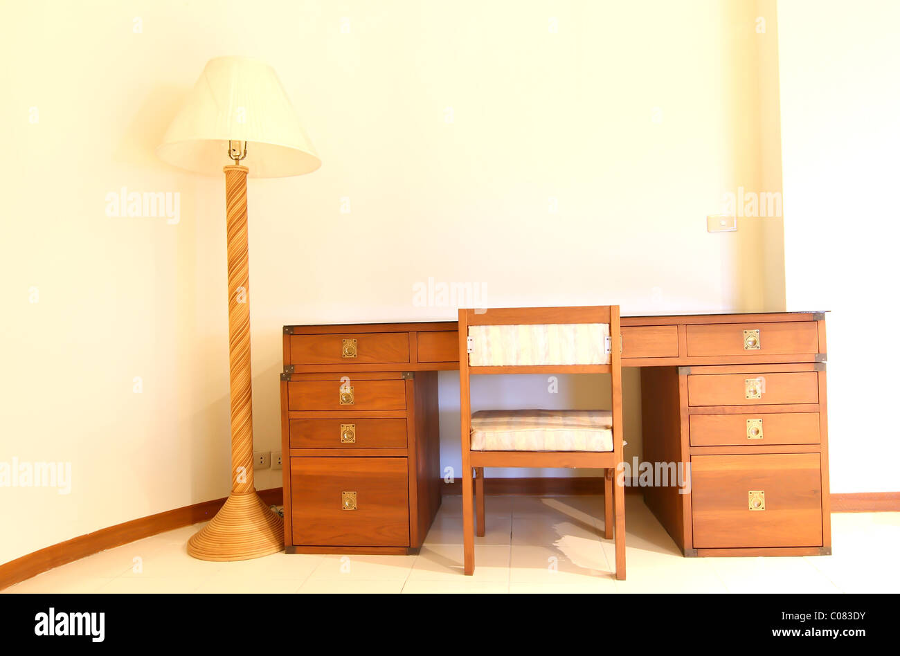 a wooden bedside table with three drawers and reading lamp Stock Photo