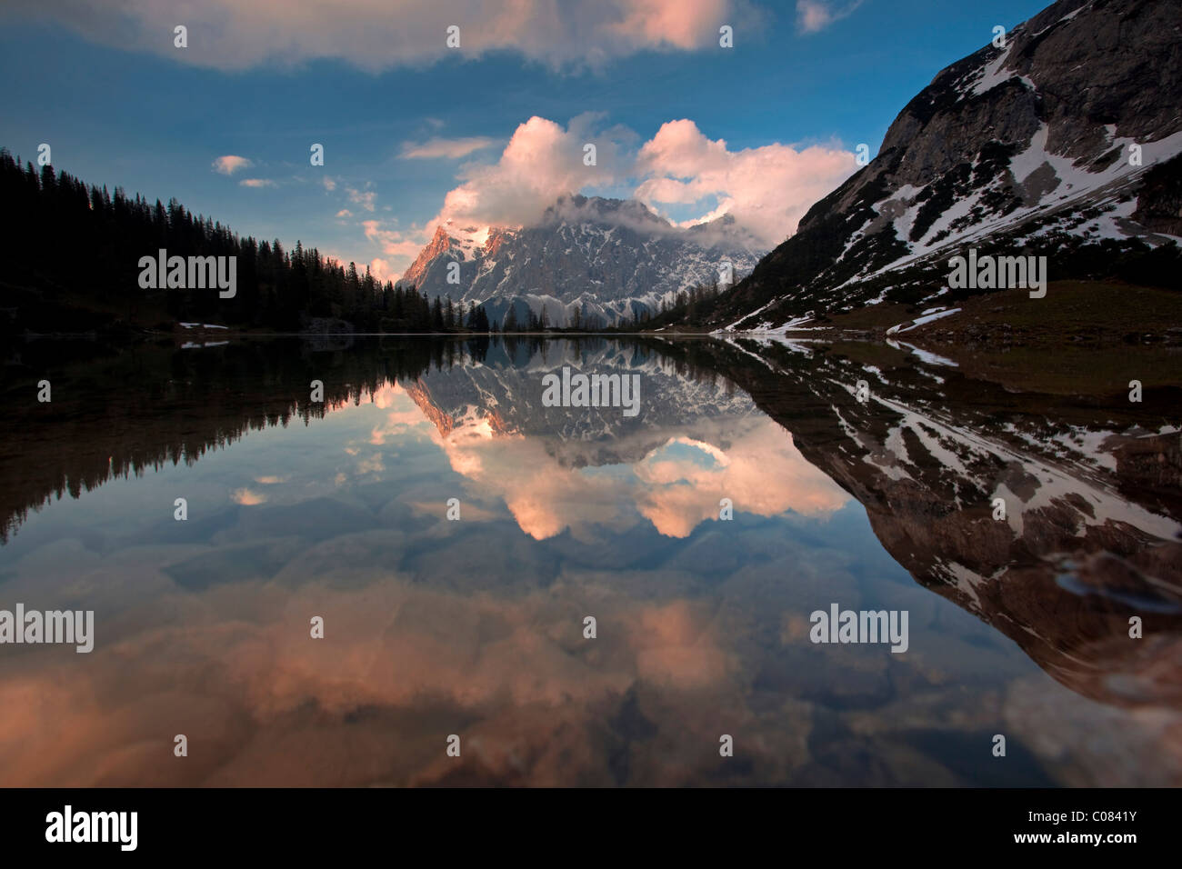 View of Zugspitze Mountain with a perfect reflection in the water of ...