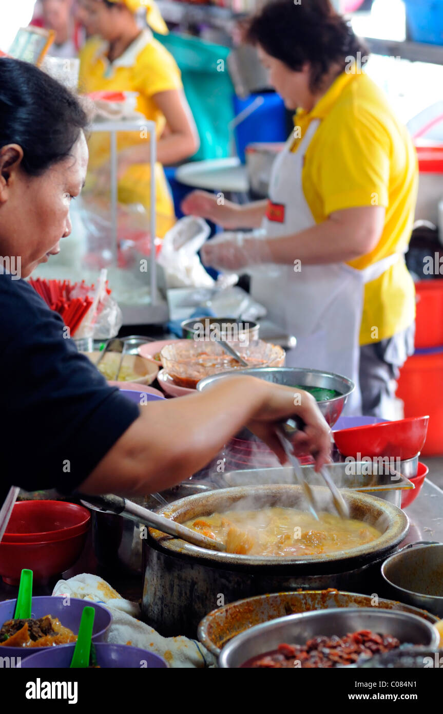 woman cook cooking noodles food wet market jalan petaling street kuala lumpur chinatown malaysia malaysian chinese food Stock Photo