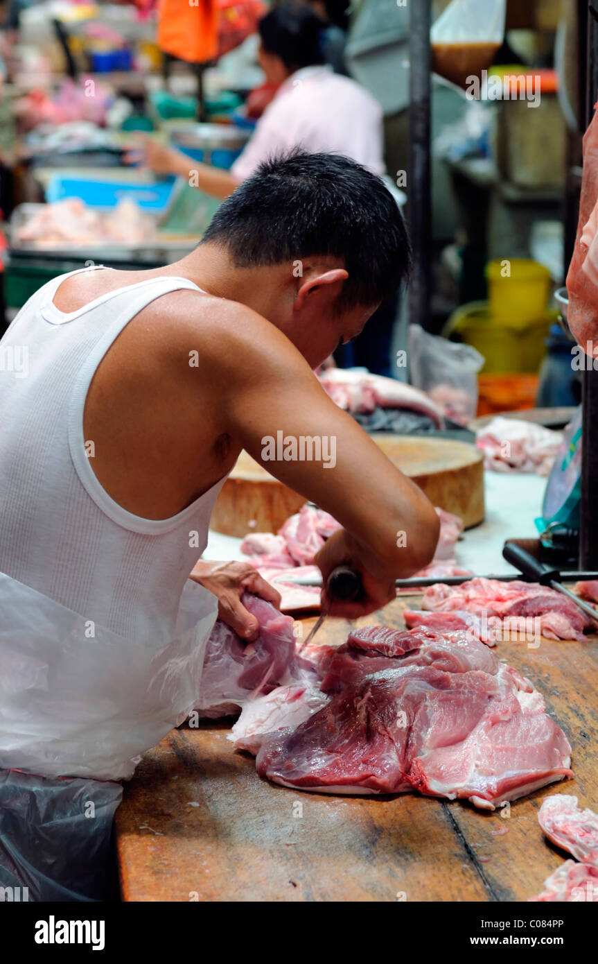 man cut prepare preparing pork meat in the crowded wet market petaling street kuala lumpur chinatown malaysia malaysian chinese Stock Photo