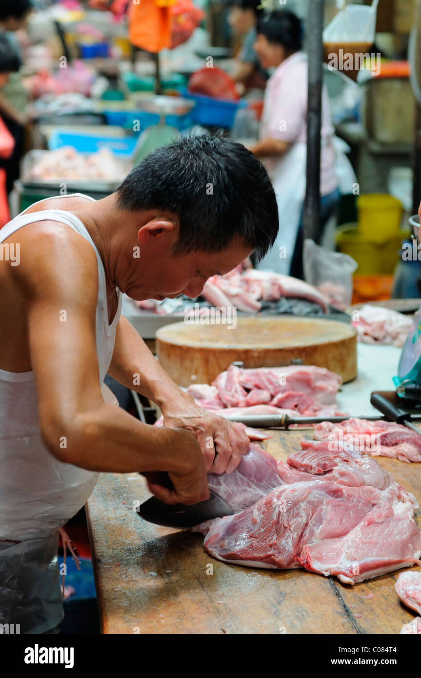 man cut prepare preparing pork meat in the crowded wet market petaling street kuala lumpur chinatown malaysia malaysian chinese Stock Photo
