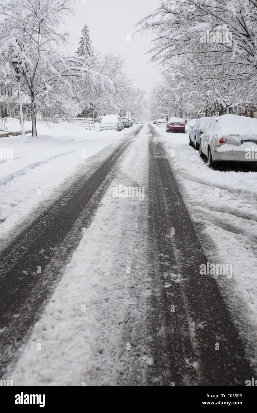 Tire tracks left by cars in a residential area after an early winter storm Stock Photo