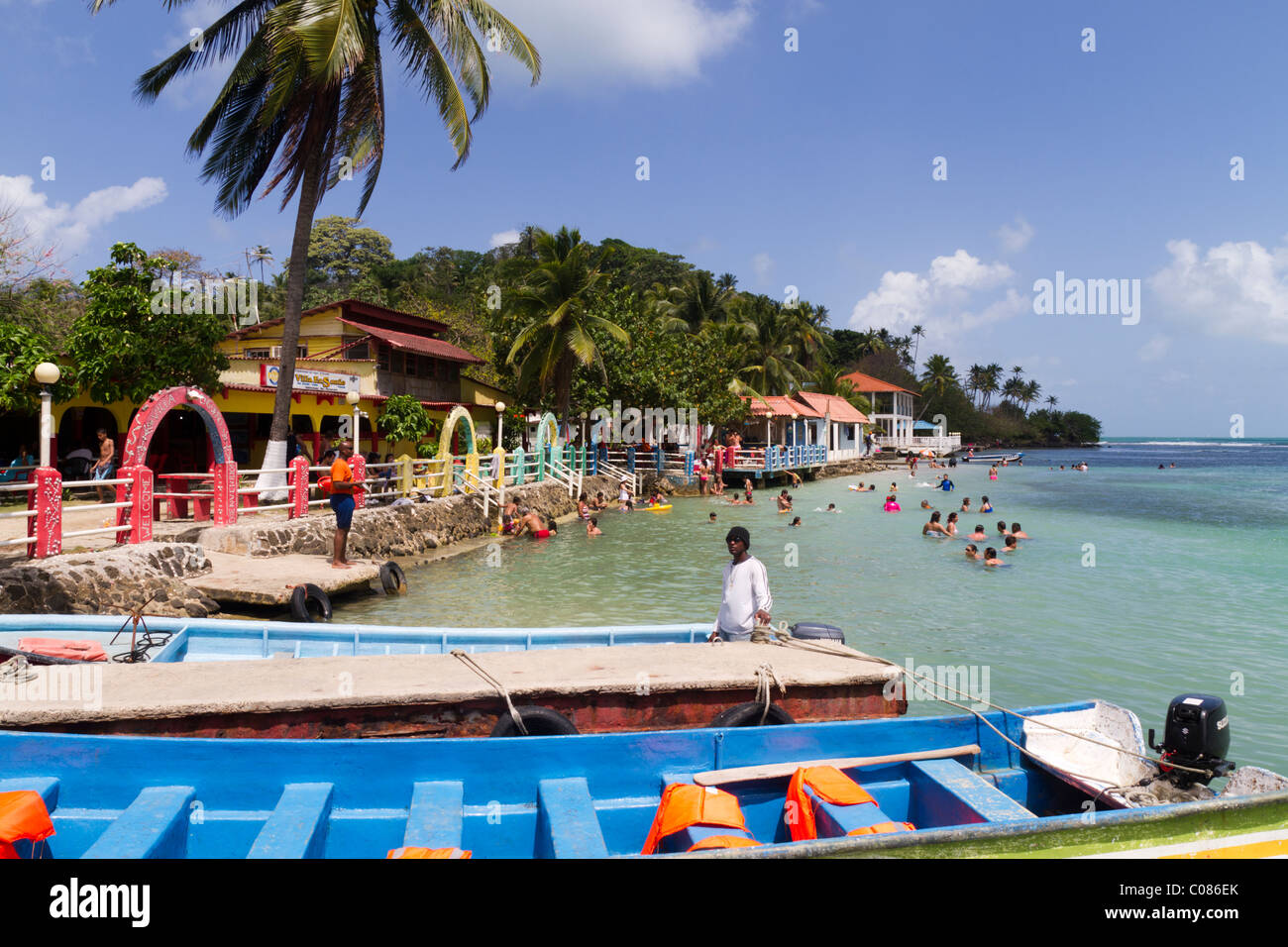 Tourists enjoying time at the beach under the eye of a Civil Protection life saver. Isla Grande, Colon, Republic of Panama. Stock Photo