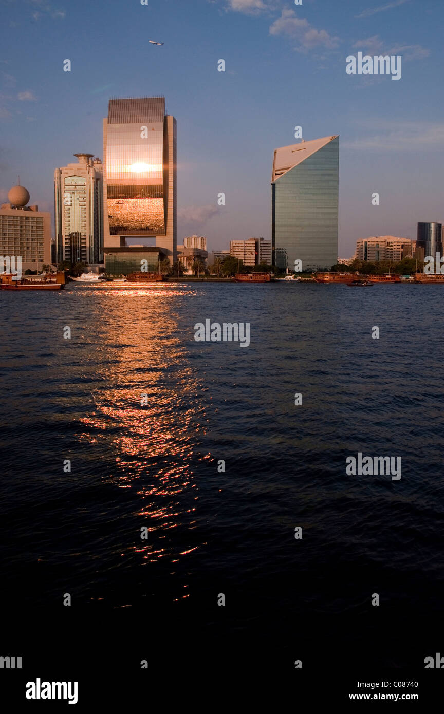 National Bank of Dubai in the evening sun with reflections in the Dubai Creek, Dubai, United Arab Emirates, Middle East Stock Photo