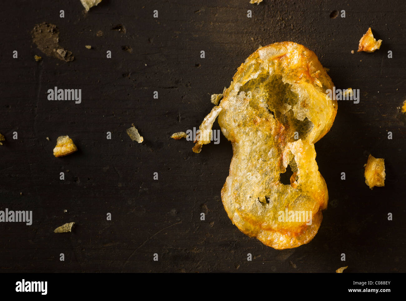 Deep Fryed Potato Chips on a dark rustic wood surface Stock Photo