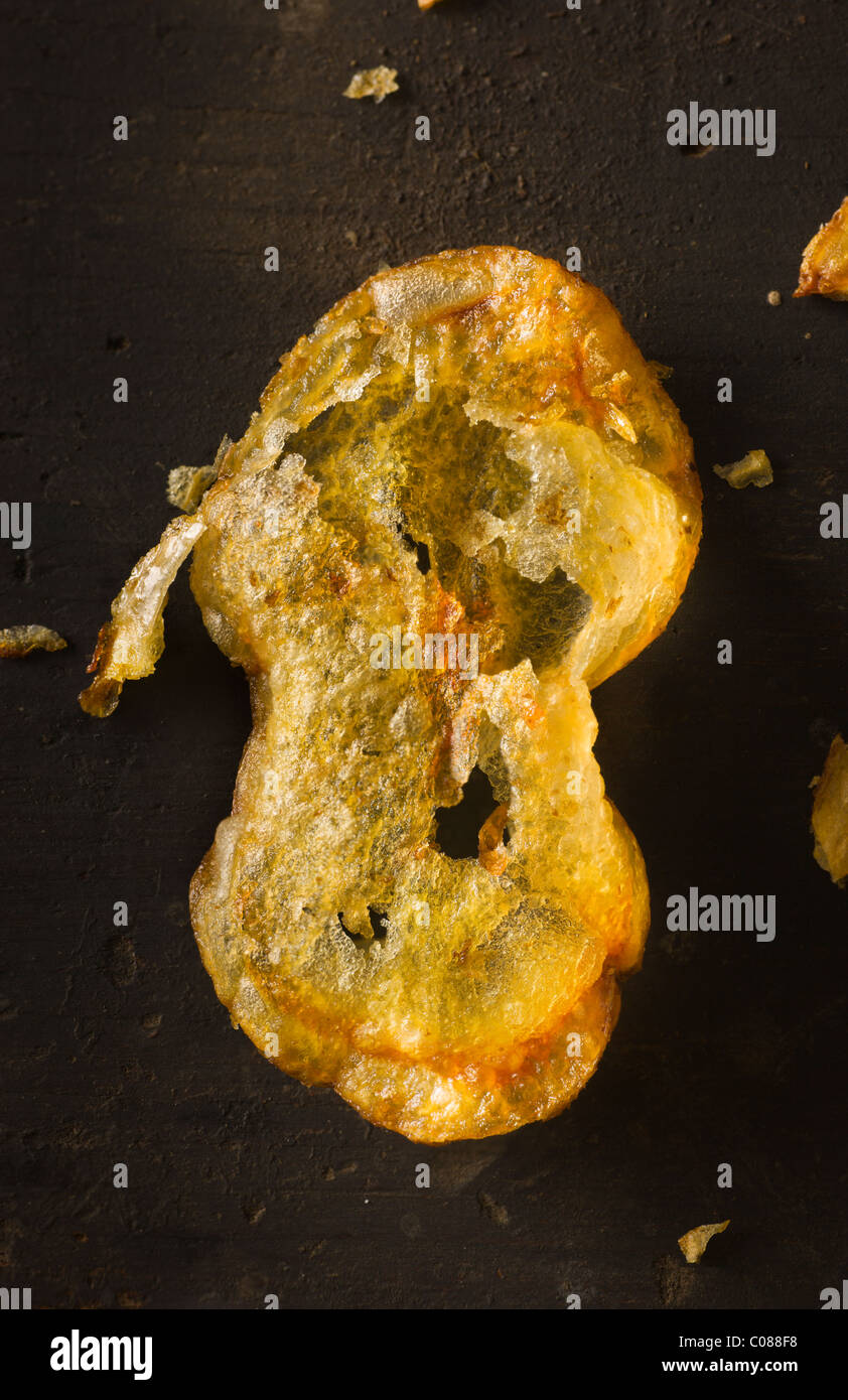 Deep Fryed Potato Chips on a dark rustic wood surface Stock Photo